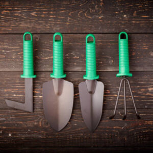 Gardening tools on wooden background flat lay top view